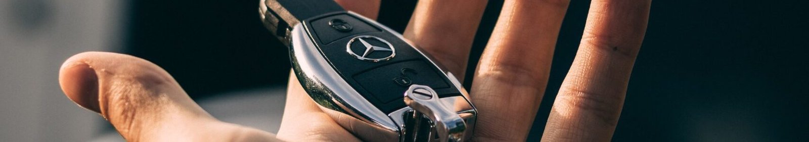 Mano sosteniendo llaves de un mercedes